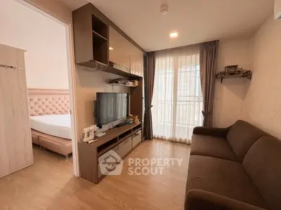 Modern living room with sleek furniture and natural light, adjacent to a cozy bedroom.