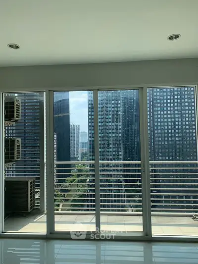 Spacious apartment with floor-to-ceiling windows offering stunning cityscape views.