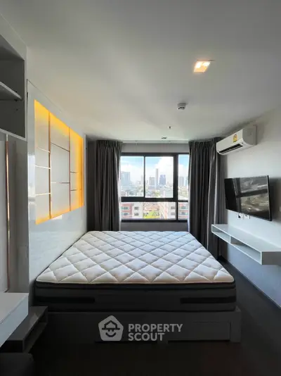 Modern bedroom with city view, featuring a large bed, wall-mounted TV, and air conditioning.