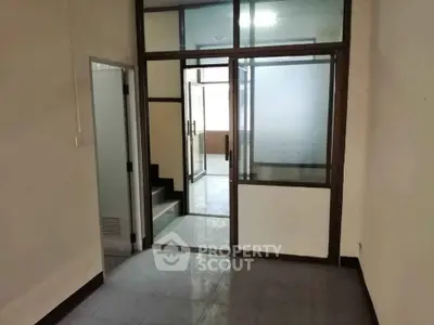 Spacious interior with glass partitions and tiled flooring, ideal for office or commercial use.