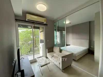 Modern studio apartment with balcony and mirrored closet in urban setting