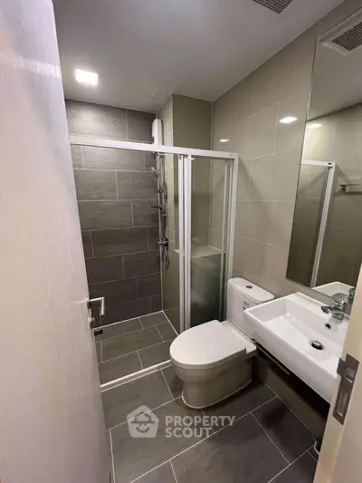 Modern bathroom with sleek shower and contemporary fixtures in a stylish apartment.