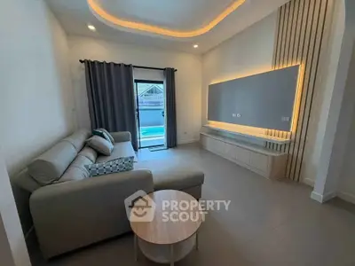 Modern living room with sleek design and pool view, featuring a cozy sofa and stylish lighting.