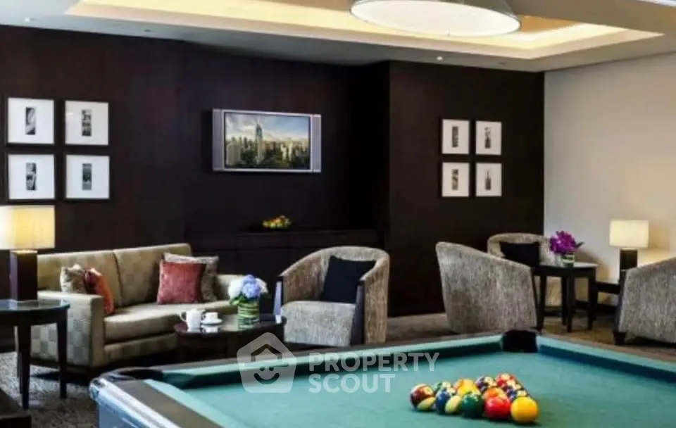 Luxurious living room with pool table and elegant seating area, perfect for entertainment.