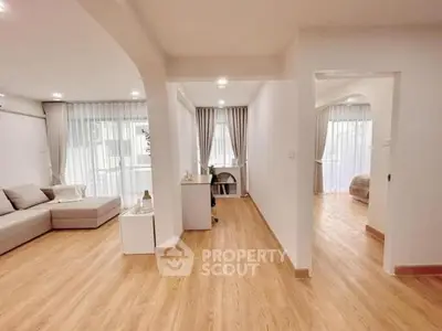 Spacious modern living room with wooden flooring and natural light