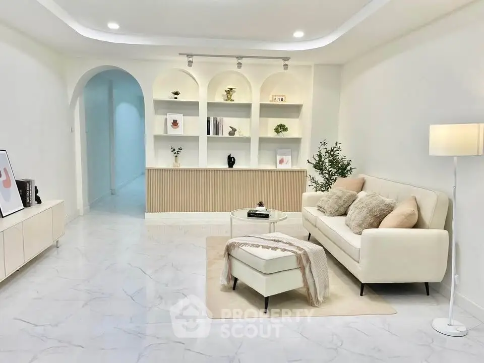 Elegant living room with modern decor, plush sofa, and stylish shelving in a bright, spacious interior.