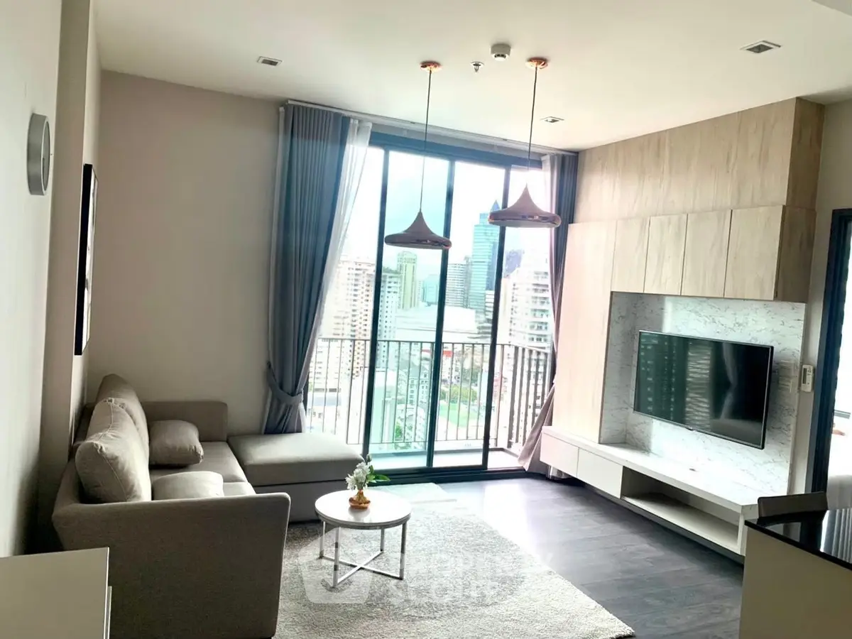 Modern living room with city view, stylish furniture, and large windows in a high-rise apartment.