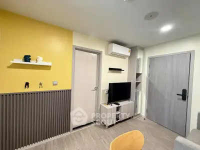 Modern living room with stylish decor and wall-mounted TV in a cozy apartment.