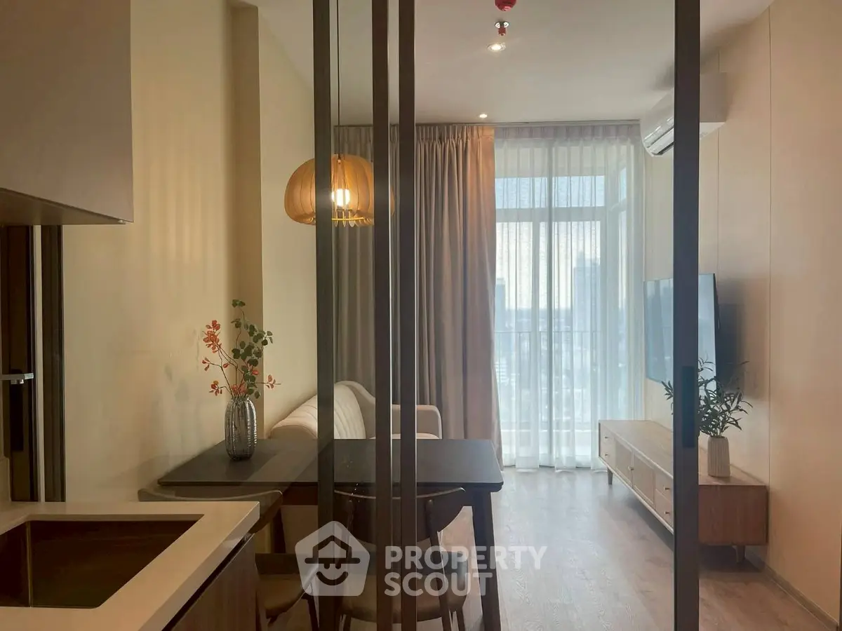 Modern living room with stylish decor and large window offering natural light.