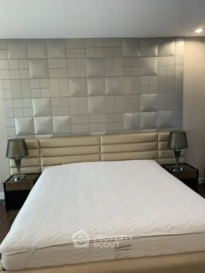 Luxurious bedroom with modern padded headboard and stylish bedside lamps