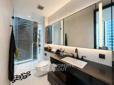 Luxurious modern bathroom with sleek fixtures and large mirror in high-rise apartment.