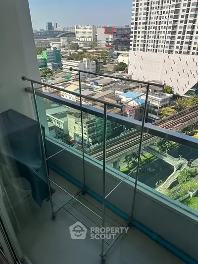 High-rise balcony with cityscape view and drying rack, ideal for urban living.