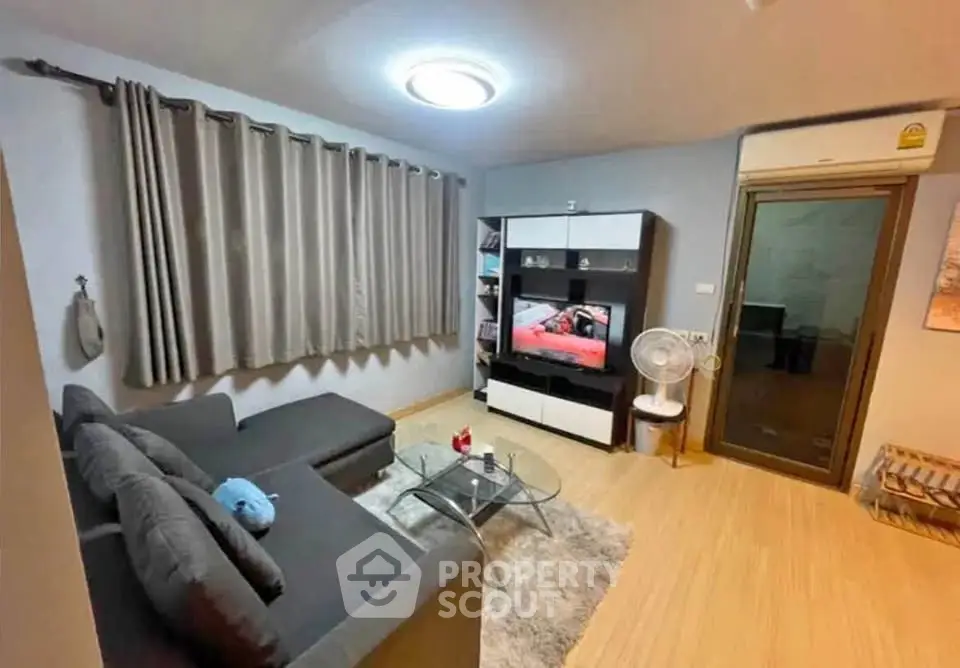 Modern living room with sleek furniture and entertainment center, featuring a cozy ambiance and stylish decor.