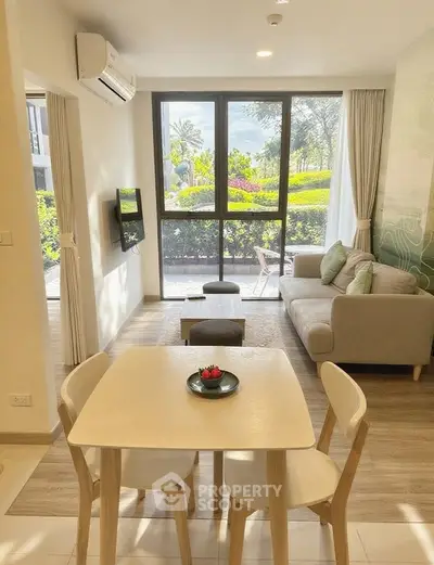 Bright and modern living room with garden view, featuring cozy seating and dining area.