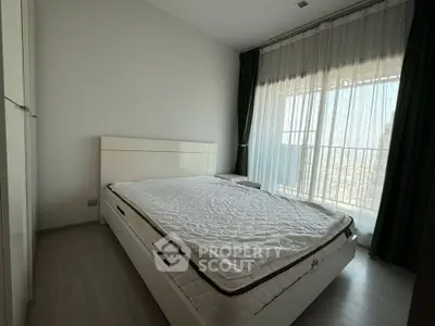 Spacious bedroom with large window and modern furnishings