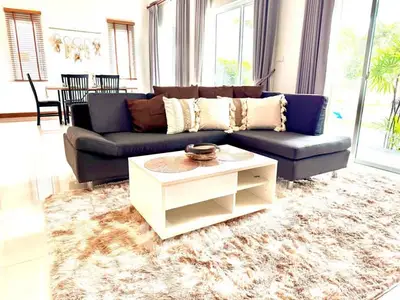 Spacious living room with modern sectional sofa and plush rug, perfect for relaxation.