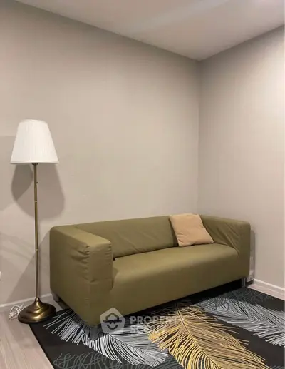 Cozy living room with olive green sofa and elegant floor lamp on stylish rug.