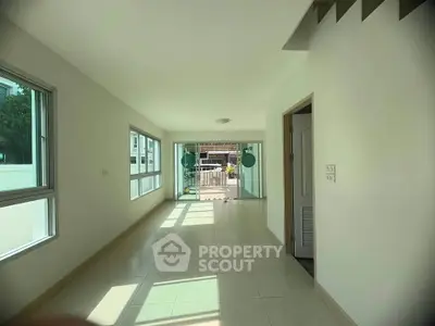 Spacious sunlit room with large windows and tiled flooring, perfect for modern living.