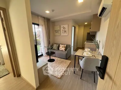Modern living room with cozy decor and open kitchen layout in a stylish apartment.