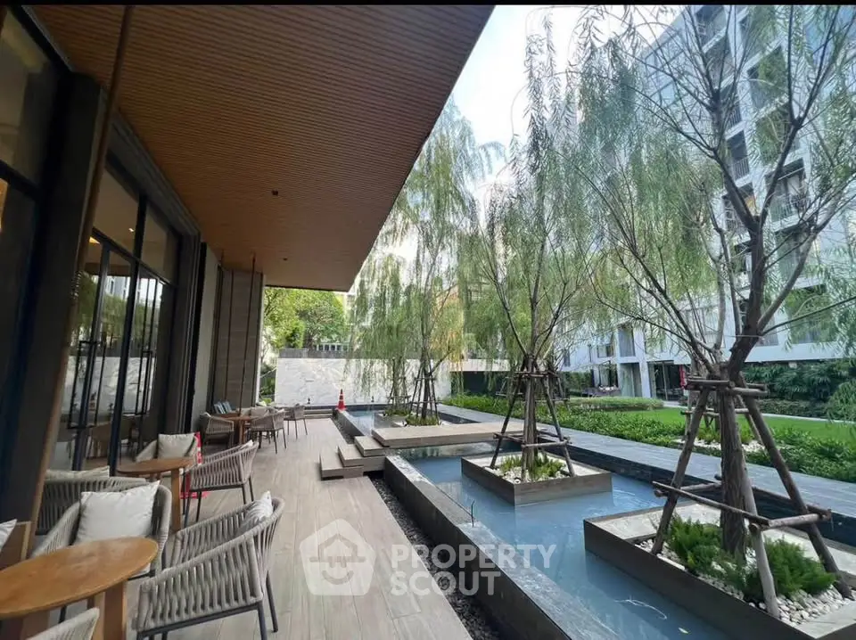 Luxurious outdoor garden area with modern seating and water features in upscale residential complex.