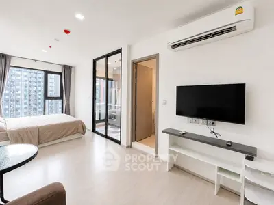 Modern studio apartment with open layout, featuring a cozy bedroom and sleek living area with city views.