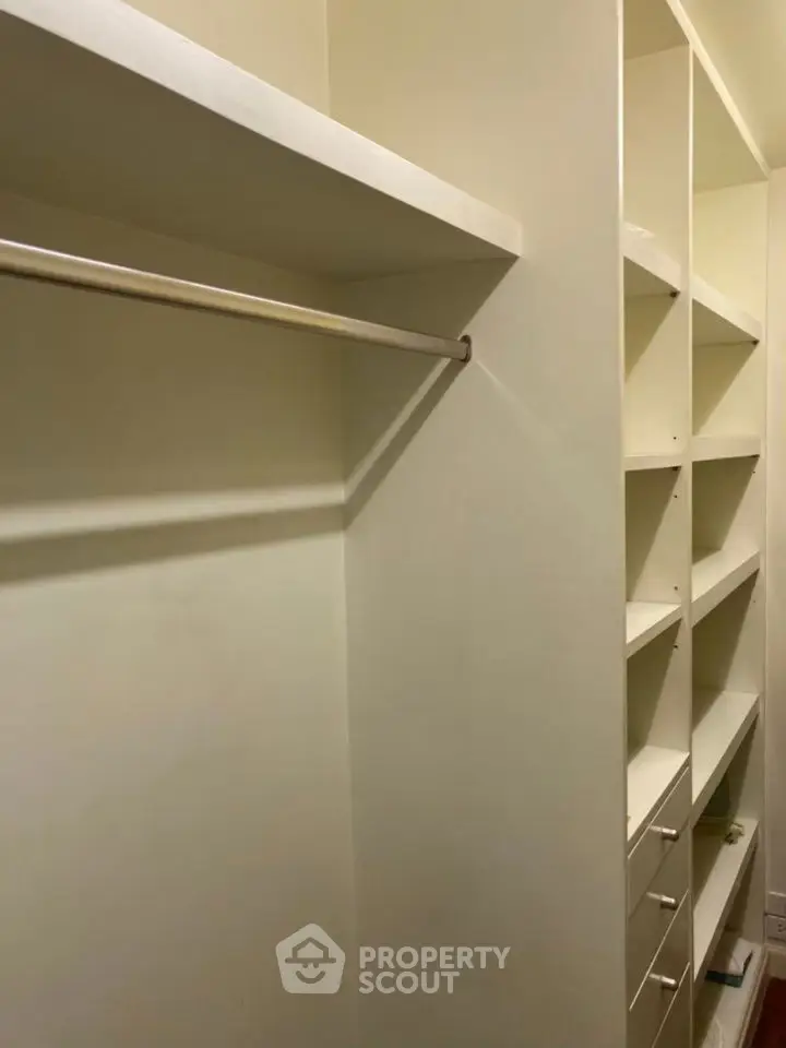 Spacious walk-in closet with ample shelving and hanging space.