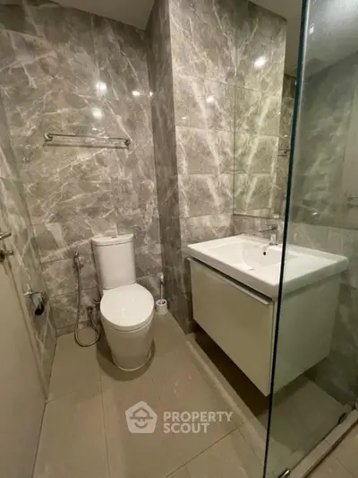 Modern bathroom with marble tiles and sleek fixtures in a contemporary apartment.