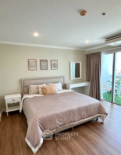 Spacious bedroom with elegant decor and balcony access in modern apartment.