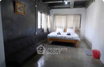 Spacious bedroom with modern concrete design and cozy furnishings