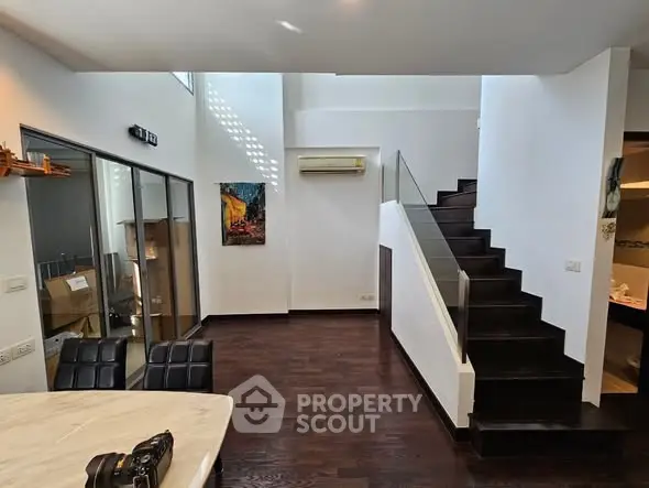 Modern duplex interior with dark wood flooring and stylish staircase