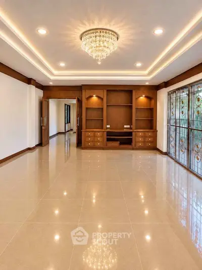 Luxurious living room with elegant chandelier and built-in wooden shelves