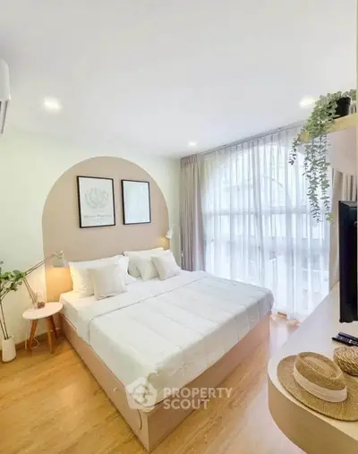 Bright and airy bedroom with modern decor and large window for natural light.