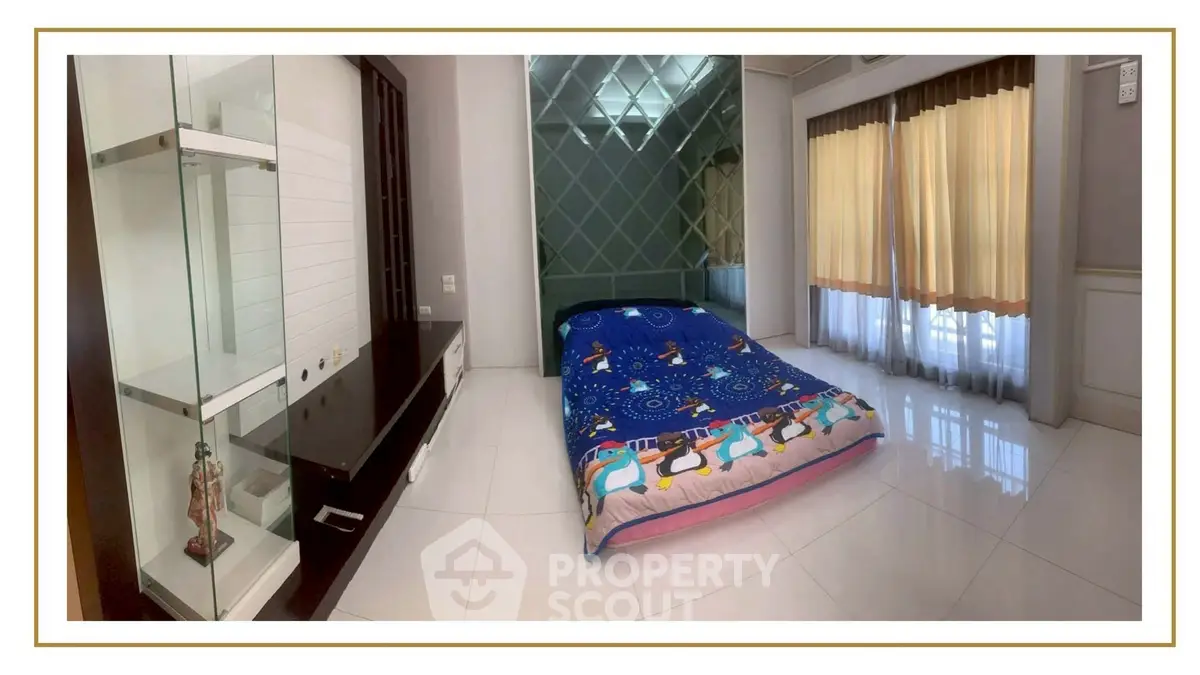 Spacious bedroom with large windows and modern decor, featuring a cozy bed and sleek furnishings.