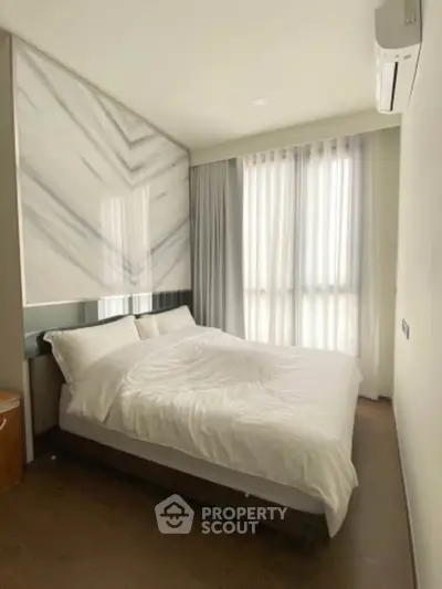 Modern bedroom with large windows and elegant decor, featuring a comfortable bed and stylish curtains.