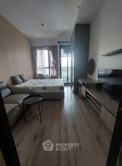 Modern studio apartment with cozy living area and balcony view