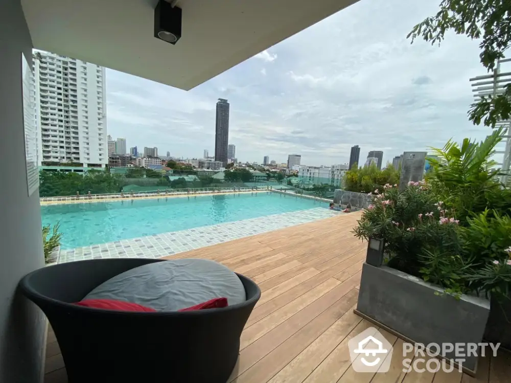 Luxurious rooftop pool with stunning city skyline view and modern seating area.