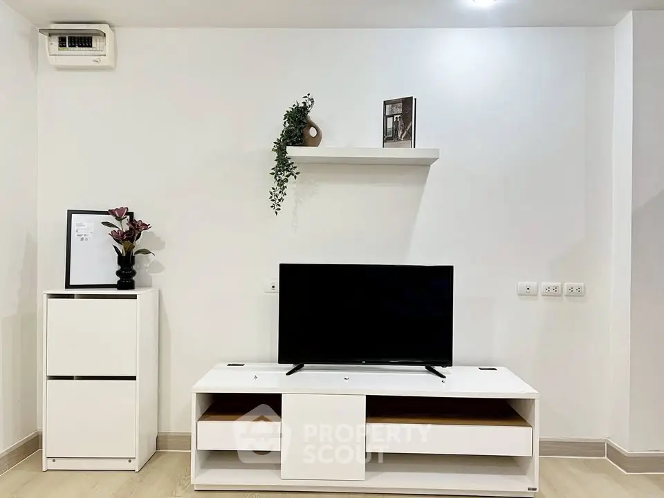 Modern living room with sleek white furniture and wall-mounted TV, perfect for contemporary urban living.