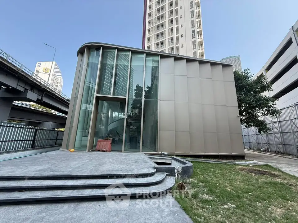 Modern architectural building with glass facade and urban surroundings, perfect for commercial or residential use.