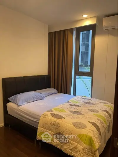 Cozy bedroom with modern decor and large window in urban apartment