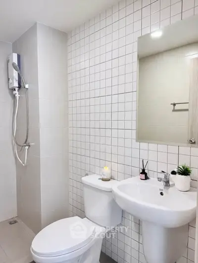 Modern bathroom with sleek white fixtures and tiled walls, featuring a shower and elegant decor.