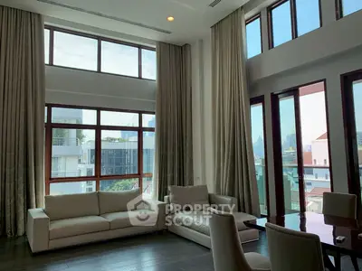 Luxurious living room with high ceilings and large windows offering city views