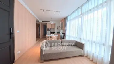 Modern living room with large windows and cozy sofa in a stylish apartment.