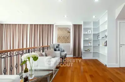 Elegant living room with hardwood floors, modern furniture, and built-in shelving