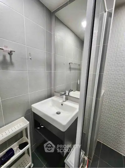 Modern bathroom with sleek sink and shower in compact space