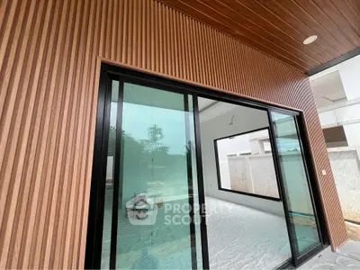 Modern home with sliding glass doors and wood paneling, showcasing sleek architectural design.