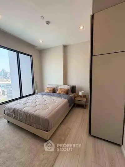 Modern bedroom with city view, featuring cozy bed and sleek wardrobe in a high-rise apartment.