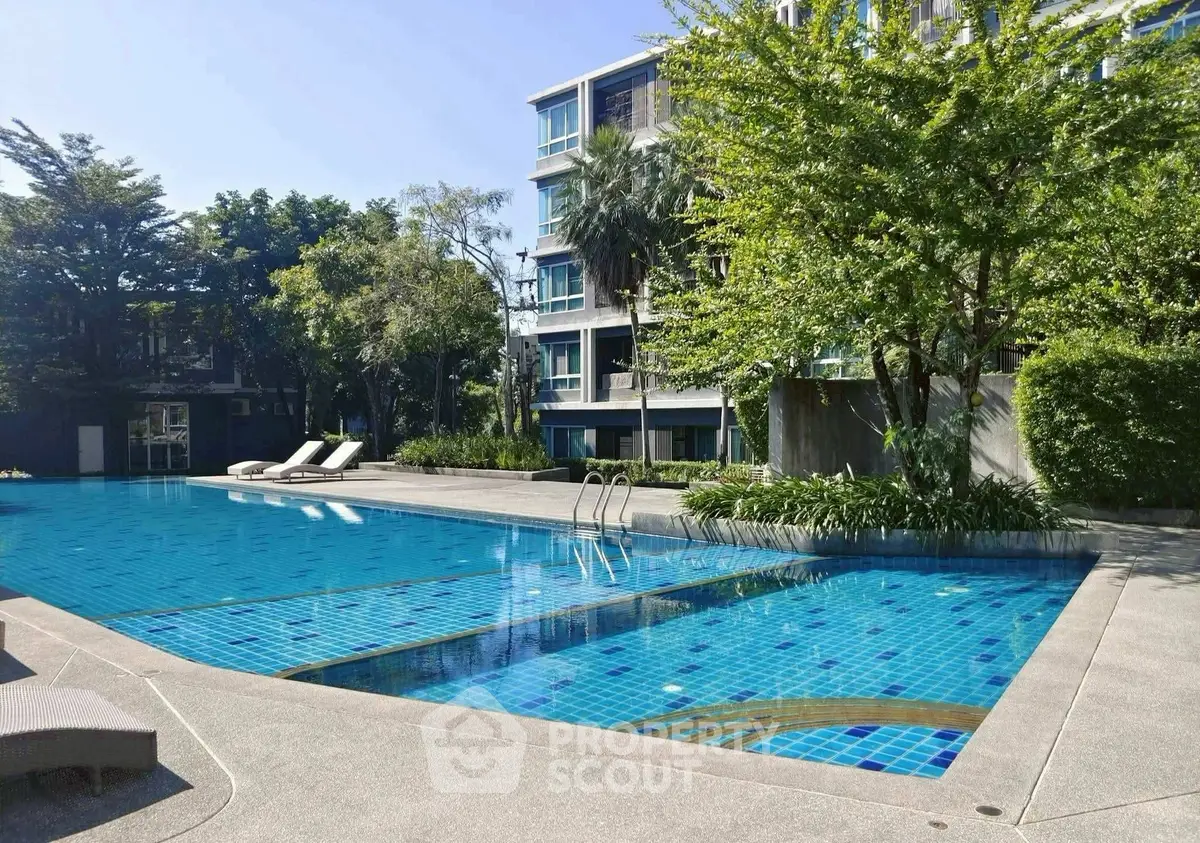 Luxurious apartment complex with inviting outdoor pool and lush greenery.
