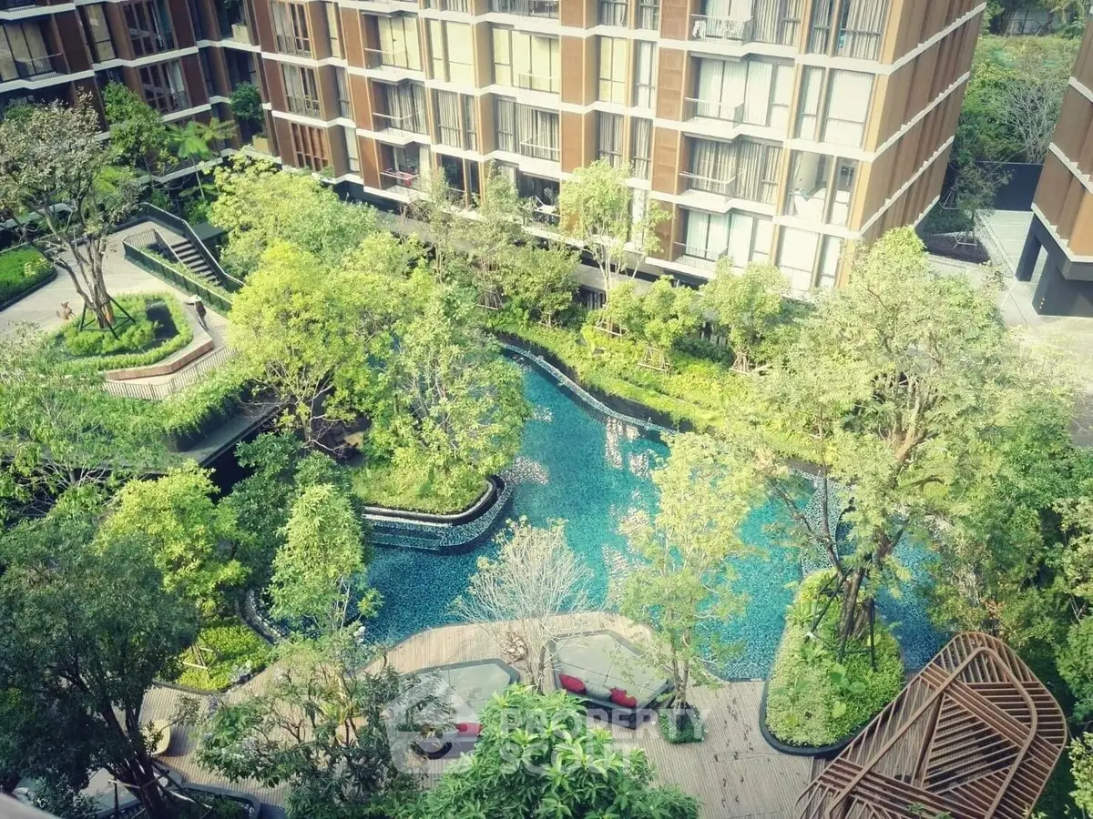 Luxurious residential complex with lush garden and serene pool view.