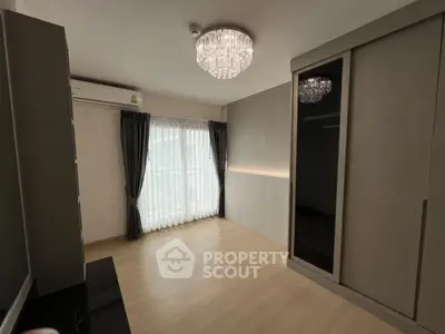 Spacious bedroom with elegant chandelier and large wardrobe
