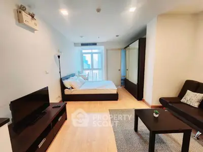 Modern studio apartment with stylish furnishings and city view, featuring a cozy living area and comfortable bed.